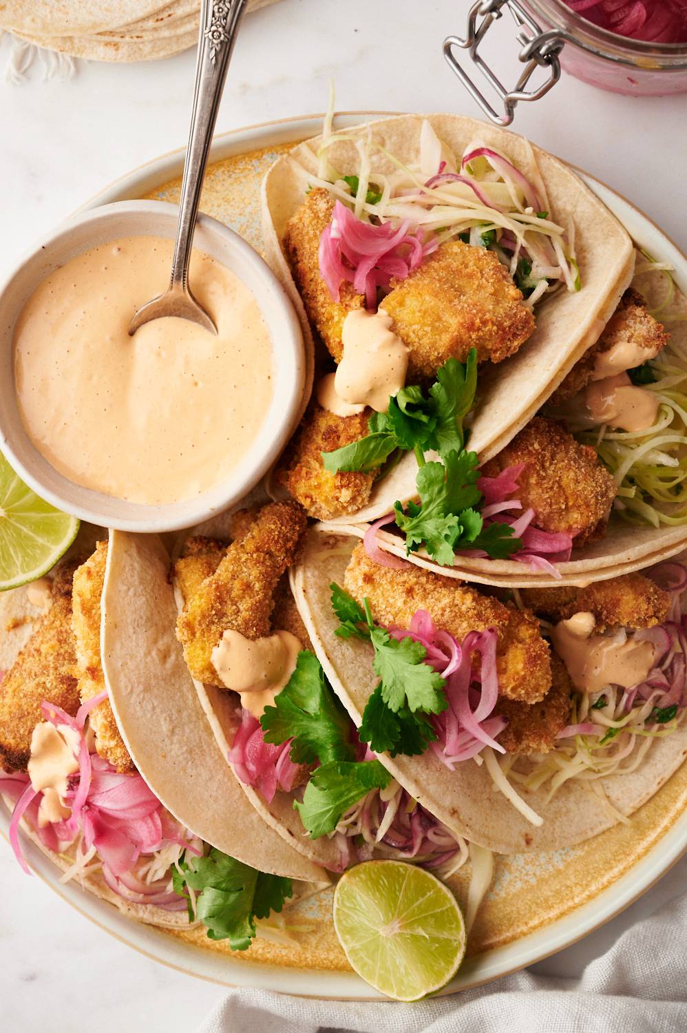 Ensenada crispy fish tacos served in corn tortillas with fish taco sauce and slaw.