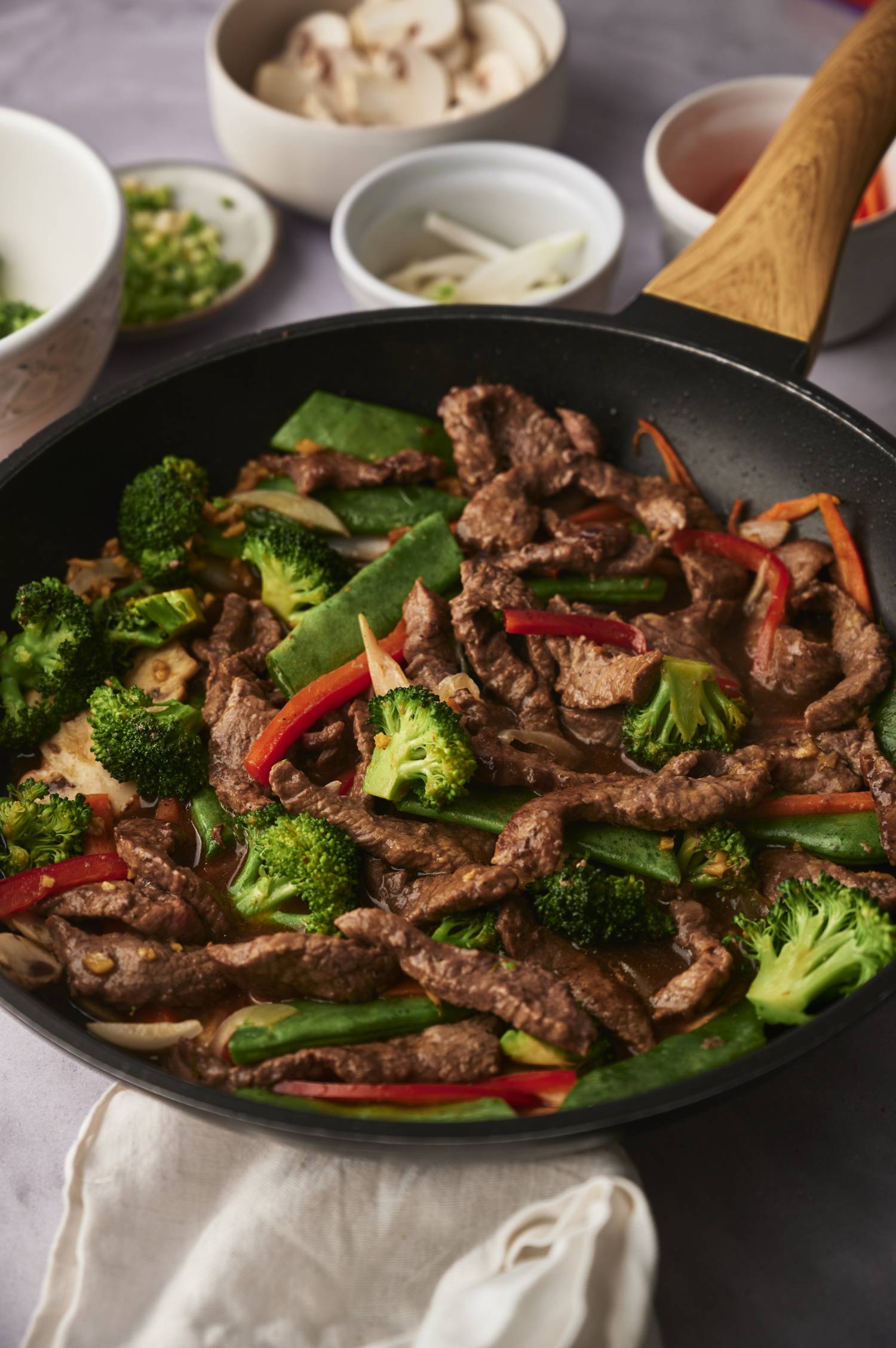 Stir fried beef with vegetables tossed with soy and honey stir fry sauce in a black skillet.