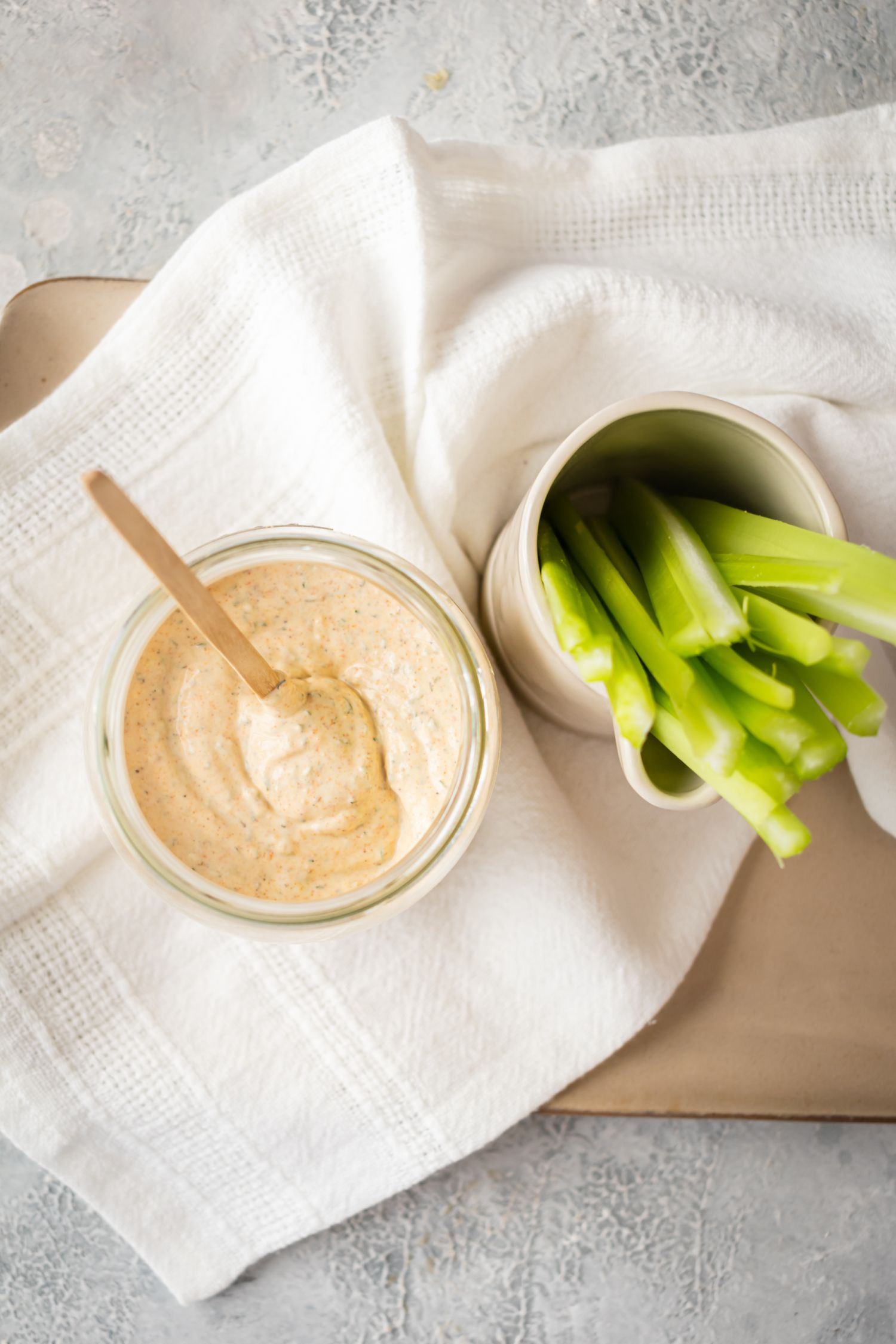 Glass jar with blackened ranch sauce served with sliced celery sticks on the side.