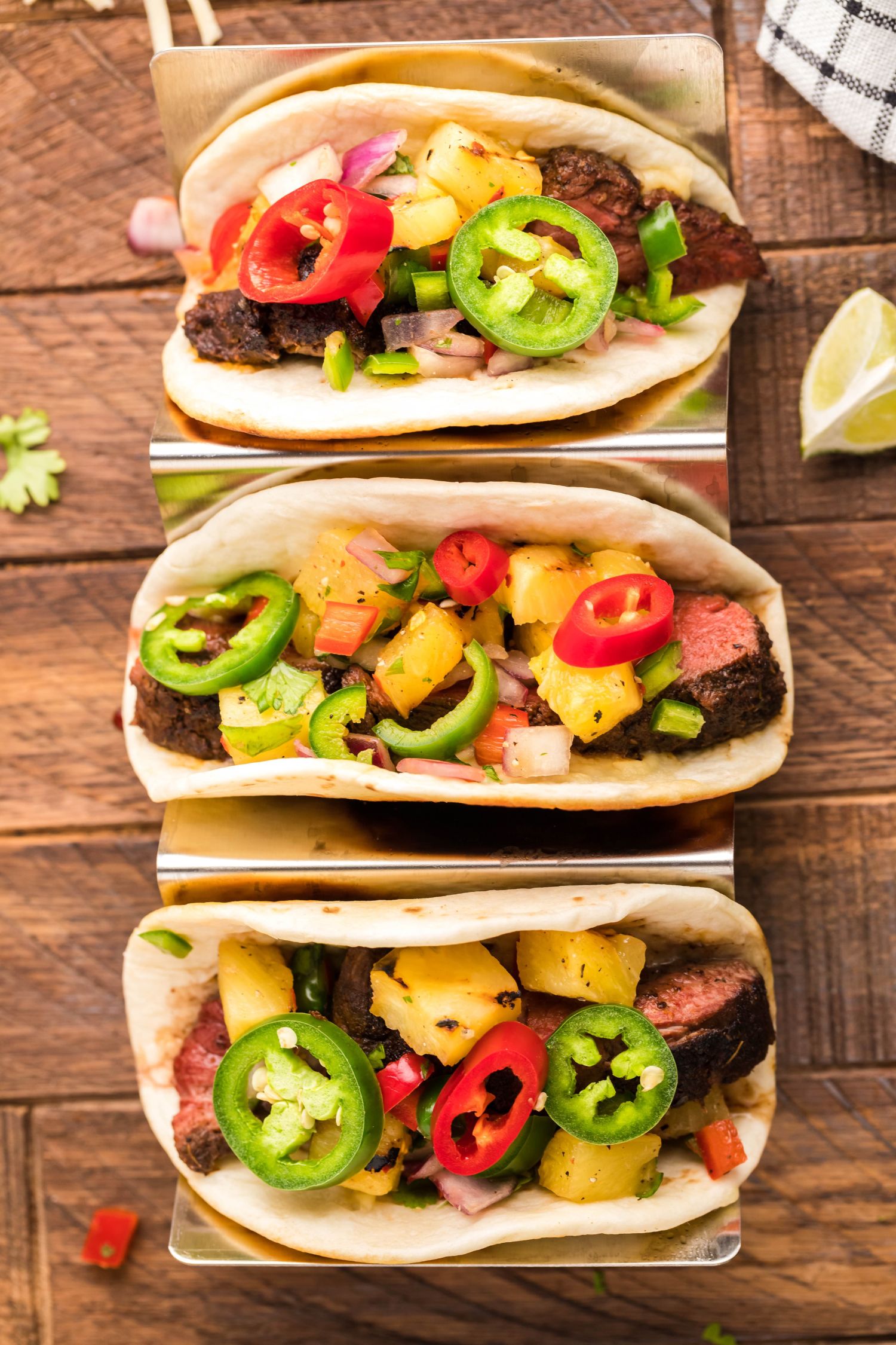 Blackened beef tacos with seared steak, salsa, cilantro, jalapenos, and red onions in three tortillas.