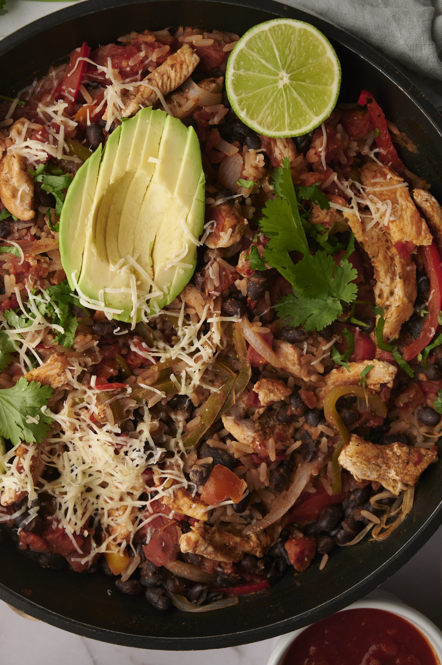 Easy chicken burrito bowls with avocado, cheese, cilantro, and limes. 