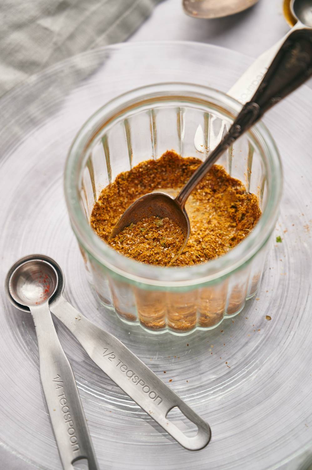 Taco seasoning for chicken tacos in glass jar with a spoon.