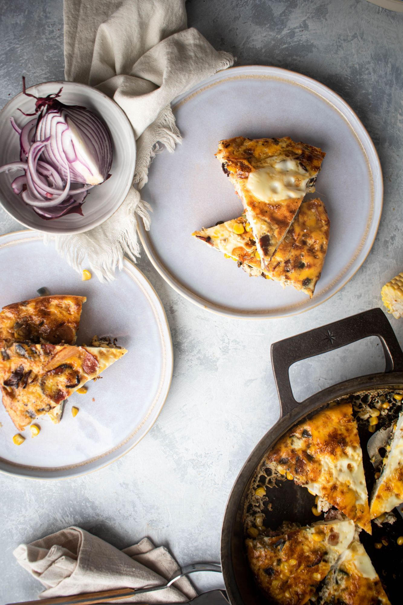 Corn frittata with bacon and jalapeno cut into slices and served in two plates.