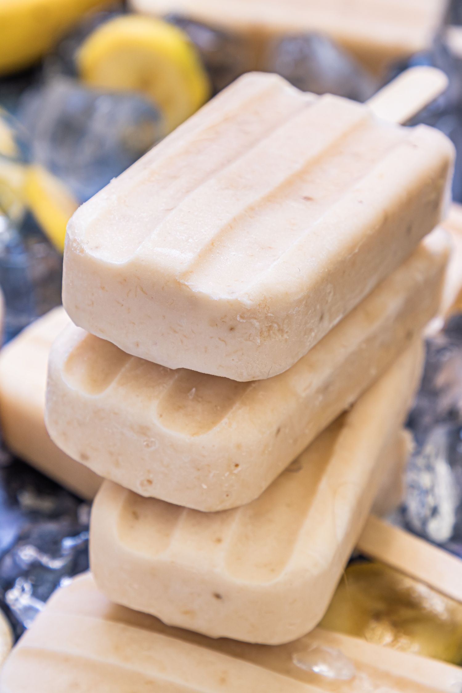 Homemade banana and yogurt popsicles stacked on top  of each other.