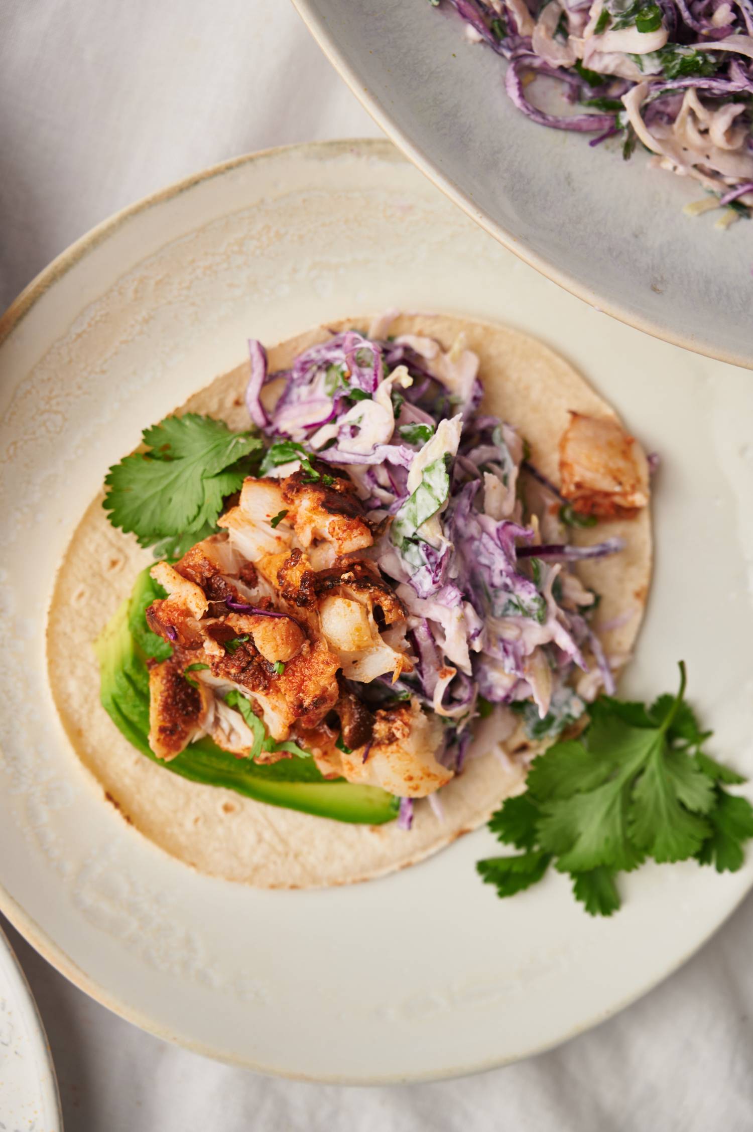 Cabbage fish taco slaw with shredded green and red cabbage tossed with a creamy sauce, cilantro, and lime juice.