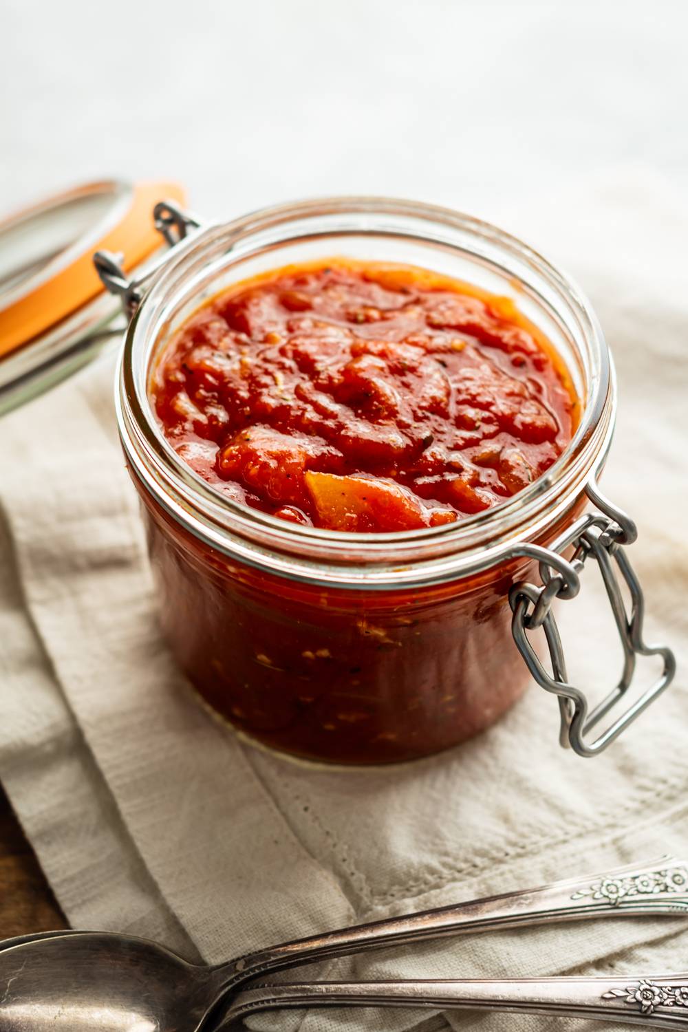 Spicy Fra Diavolo sauce with tomato sauce and red chile peppers in a glass jar.