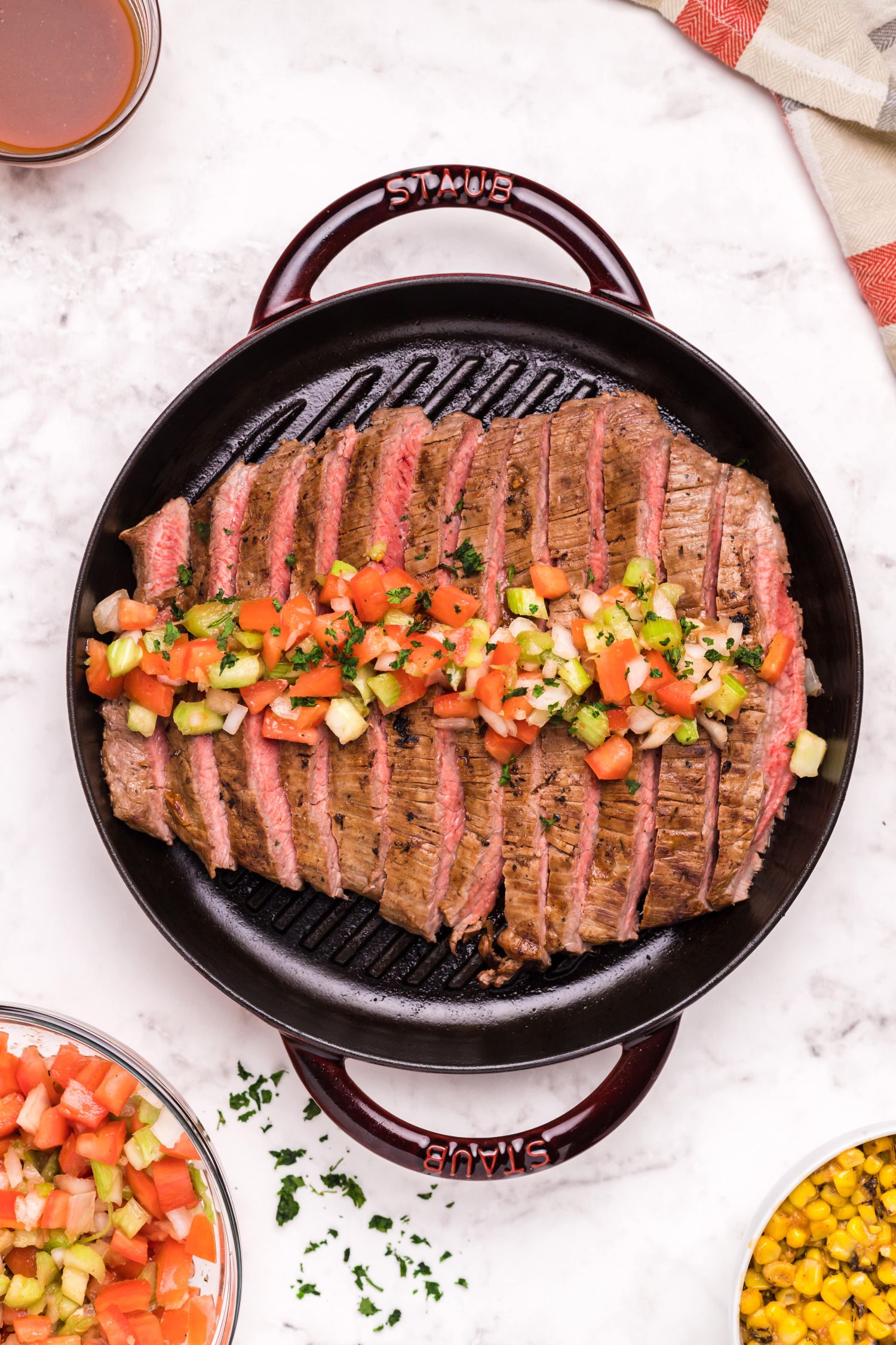 Grilled marinated flank steak with bloody mary salsa on a grill pan.