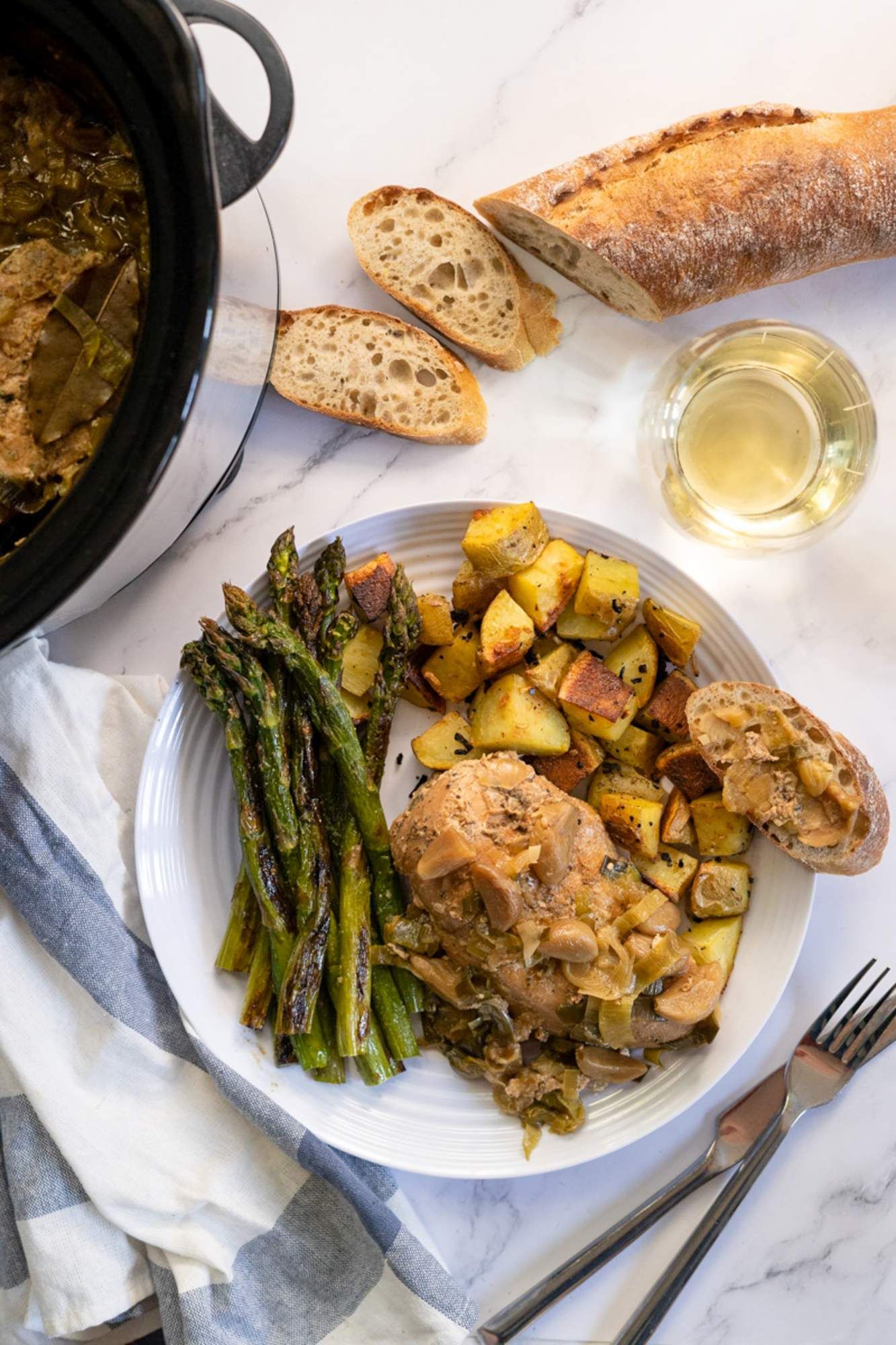 Slow cooker 40 clove garlic chicken served with roasted potatoes and asparagus.