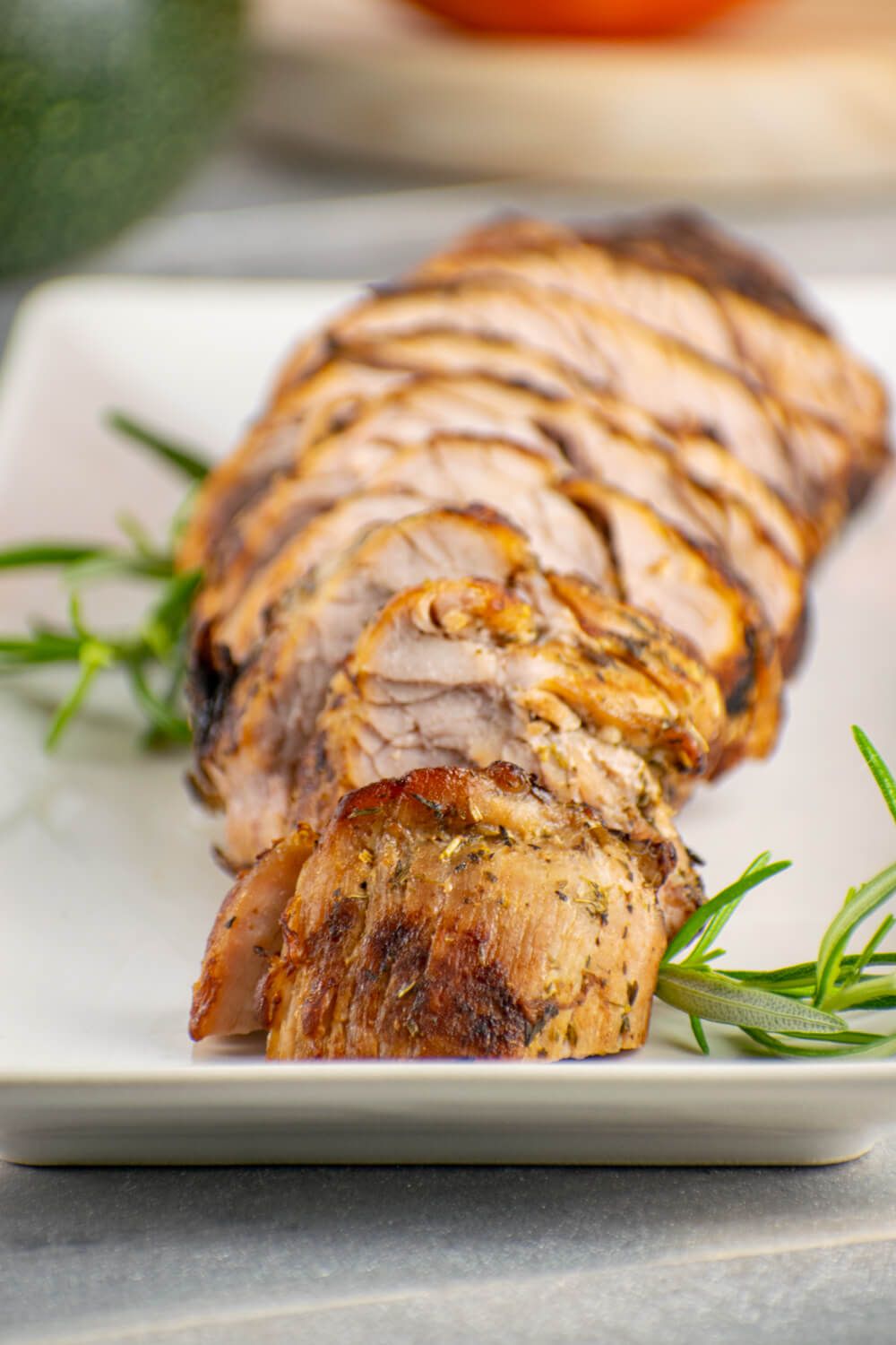 Grilled pork tenderloin with Mediterranean spices cut into slices with rosemary.