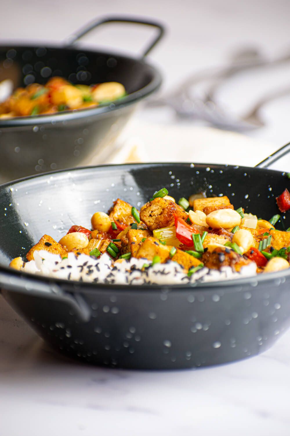 Healthy Kung Pao Tofu with white rice, crispy tofu, celery, red pepper, and peanuts in a sweet and spicy sauce.