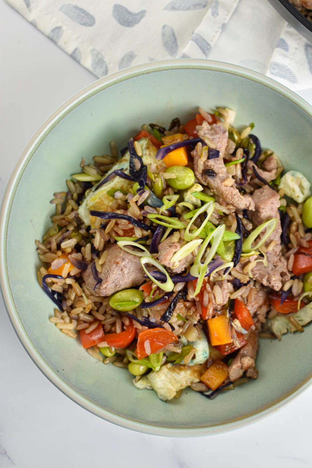 Healthy pork fried rice with pork tenderloin, vegetables, and fried rice on a plate.