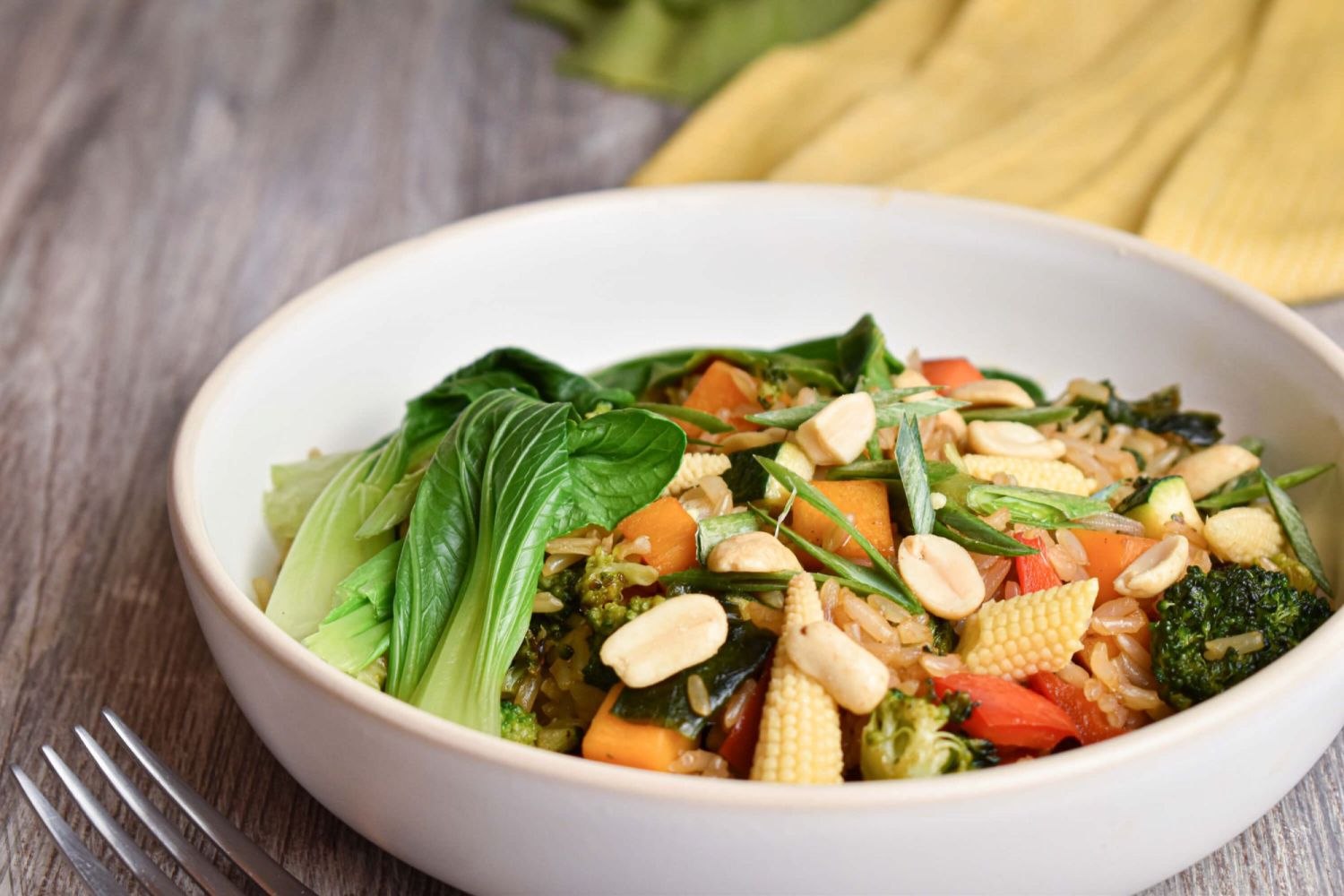 Teriyaki veggie bowls with bok choy, carrots, broccoli, and cabbage on a bed of brown rice.