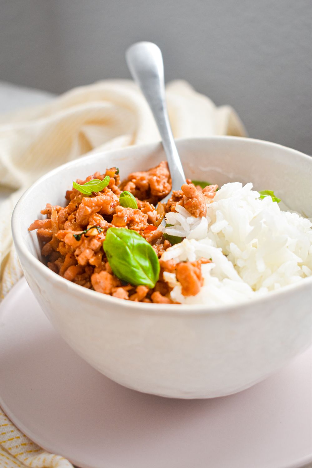 Thai Ground Turkey in a bowl with Thai basil, lean ground turkey, and white rice with a fork on the side.