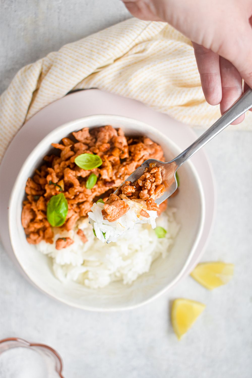 Ground turkey with Thai spices in a bowl with rice being picked up with a fork.