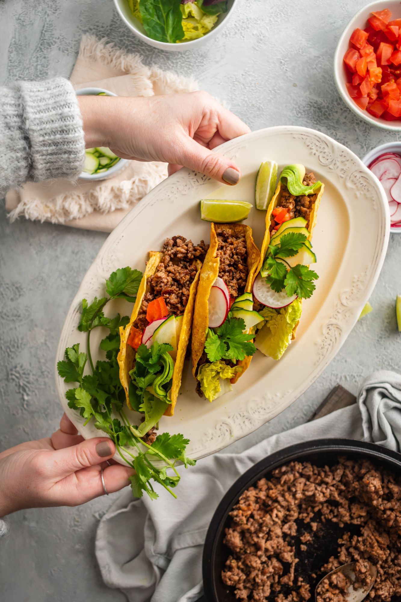 Ground beef tacos with ancho chili seasoning in crispy baked taco shells with lettuce, tomatoes, and cilantro.