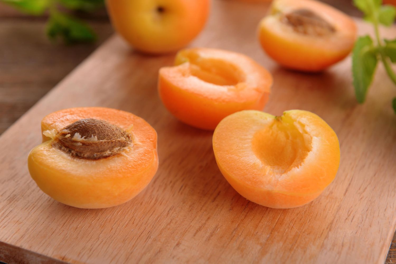 Fresh apricots on a cutting board before being used for an apricot crumble recipe.