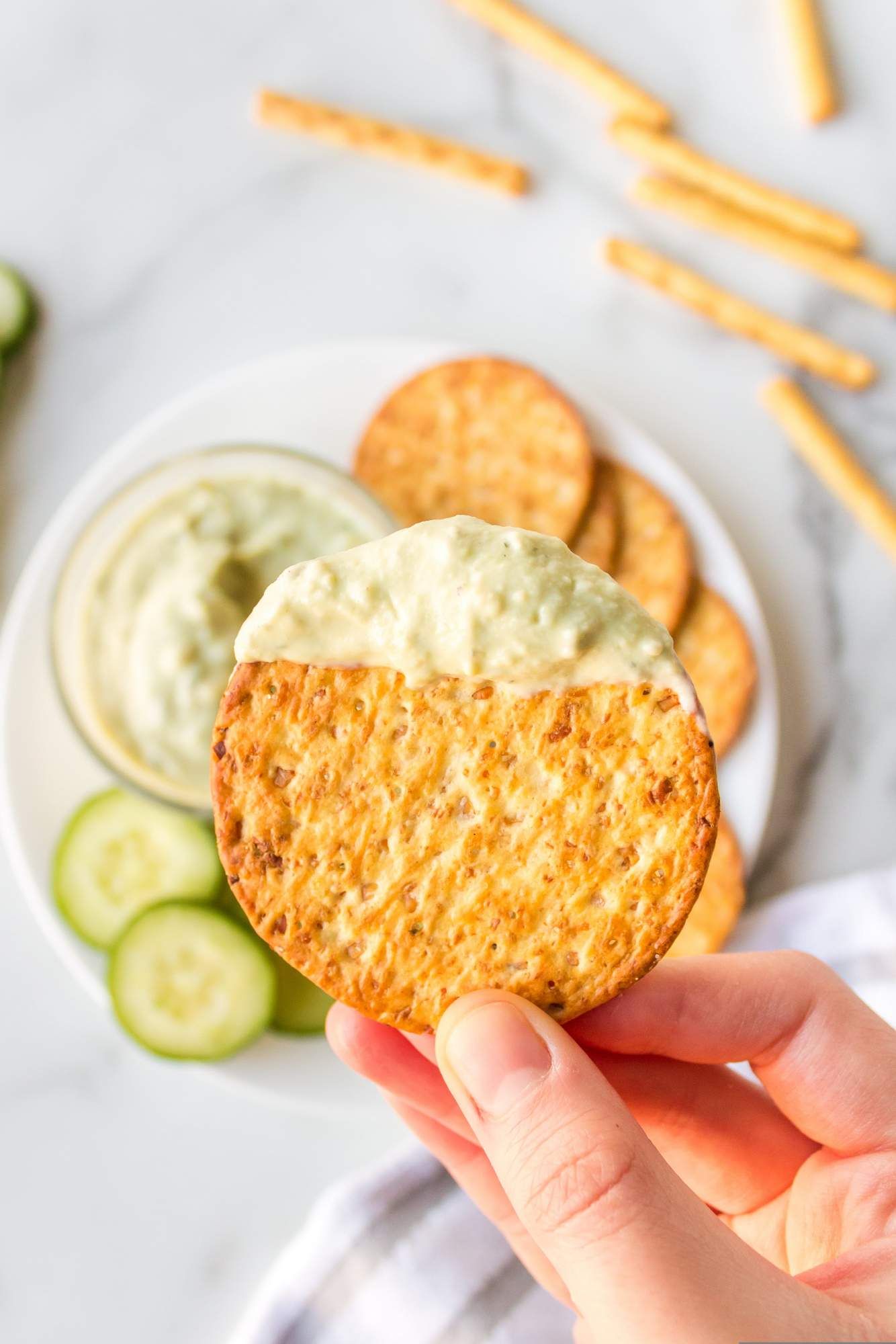 Avocado dip with ranch seasoning and Greek yogurt on a whole wheat cracker.