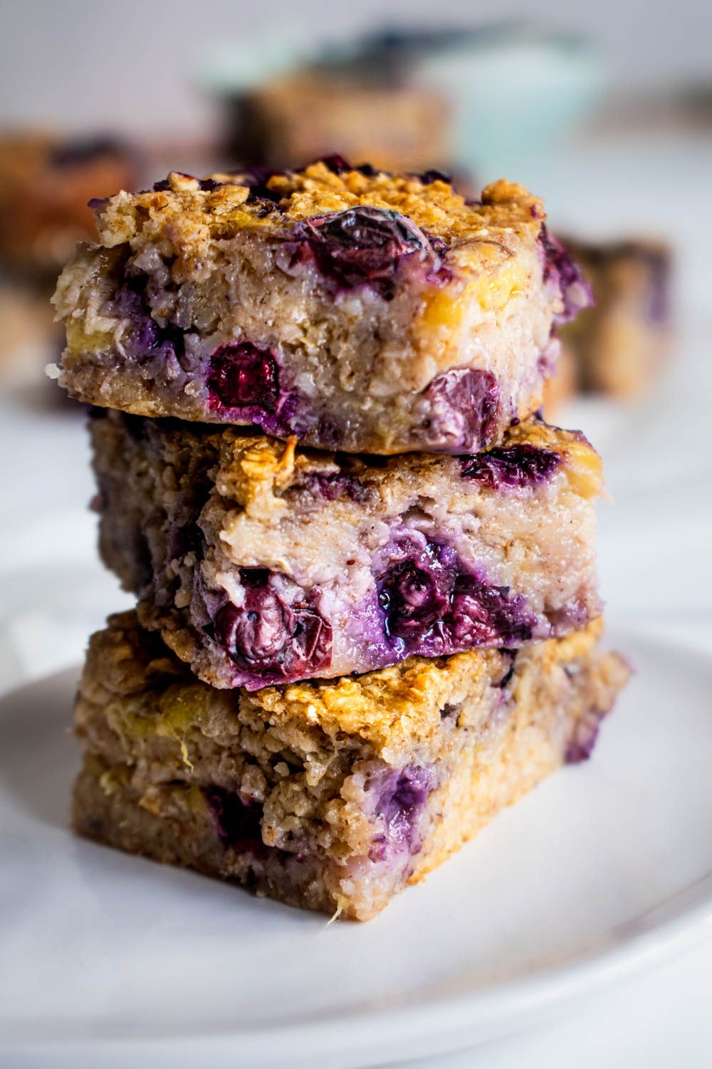 Oatmeal baked with blueberries and bananas stacked on top of a plate.