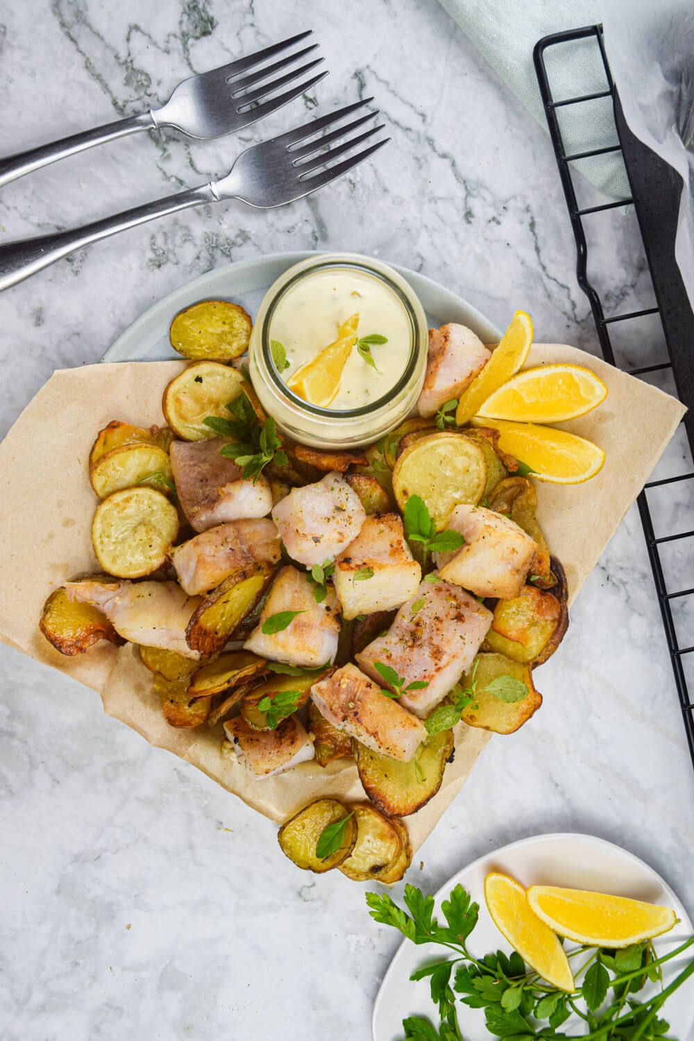 Healthy fish and chips baked in the oven until crispy with tartar sauce and lemon.