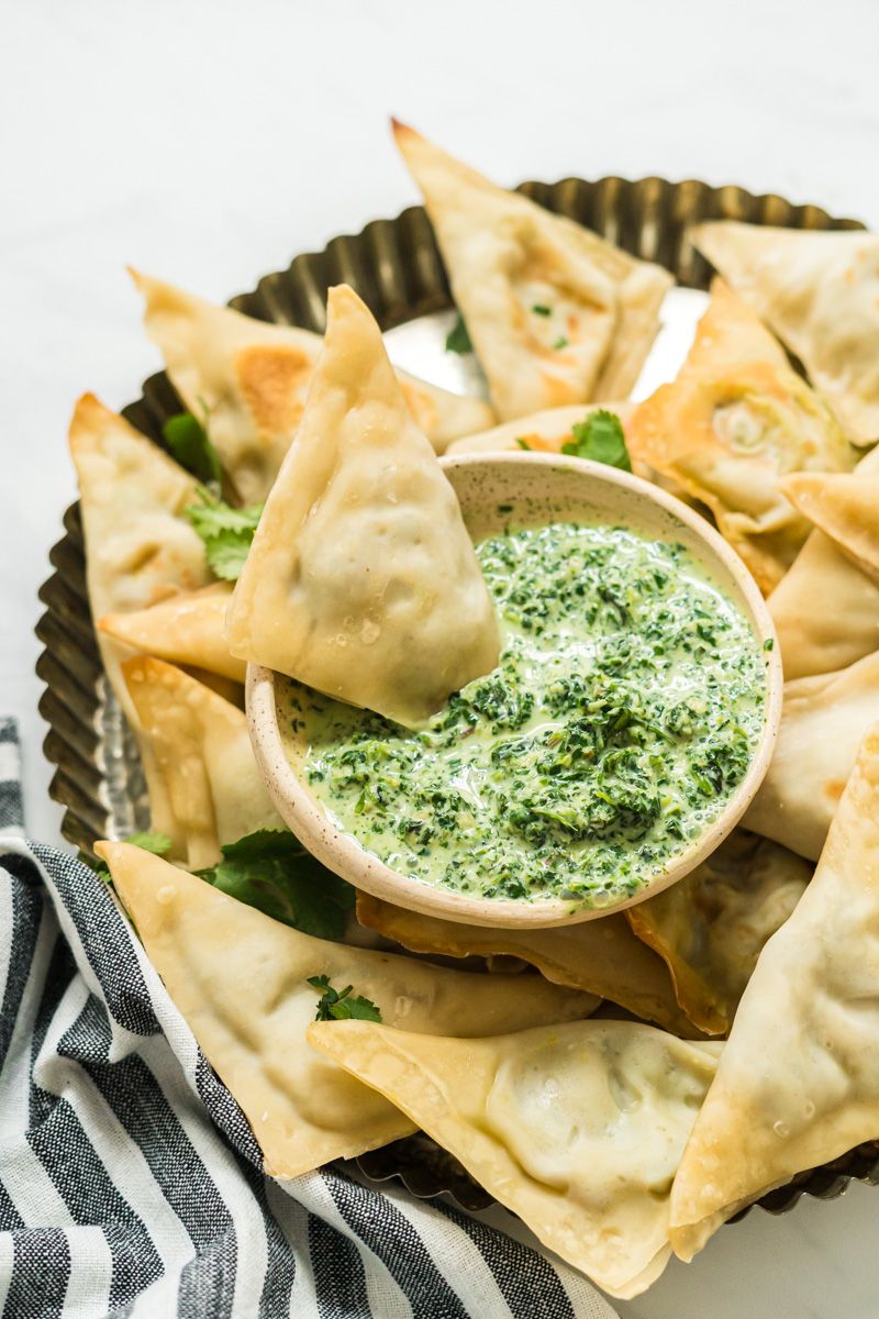 Shortcut samosa baked with potato, cauliflower, potato, peas, and Indian spices on a plate with cilantro dipping sauce.