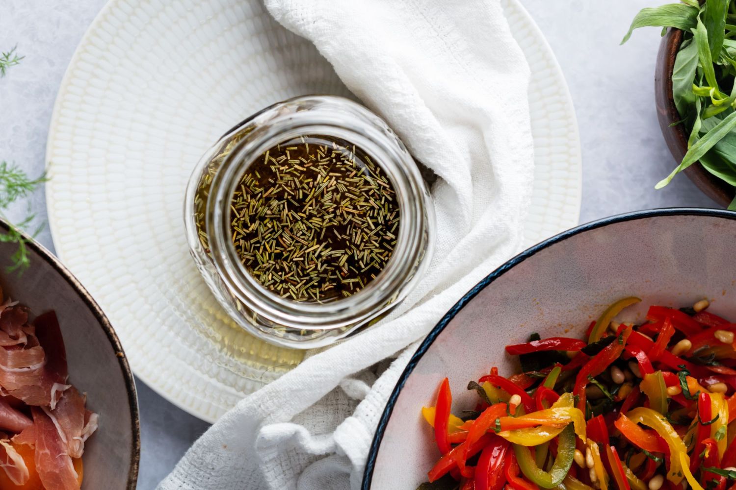 Marinade for grilled vegetables in a glass jar with grilled peppers on the side.