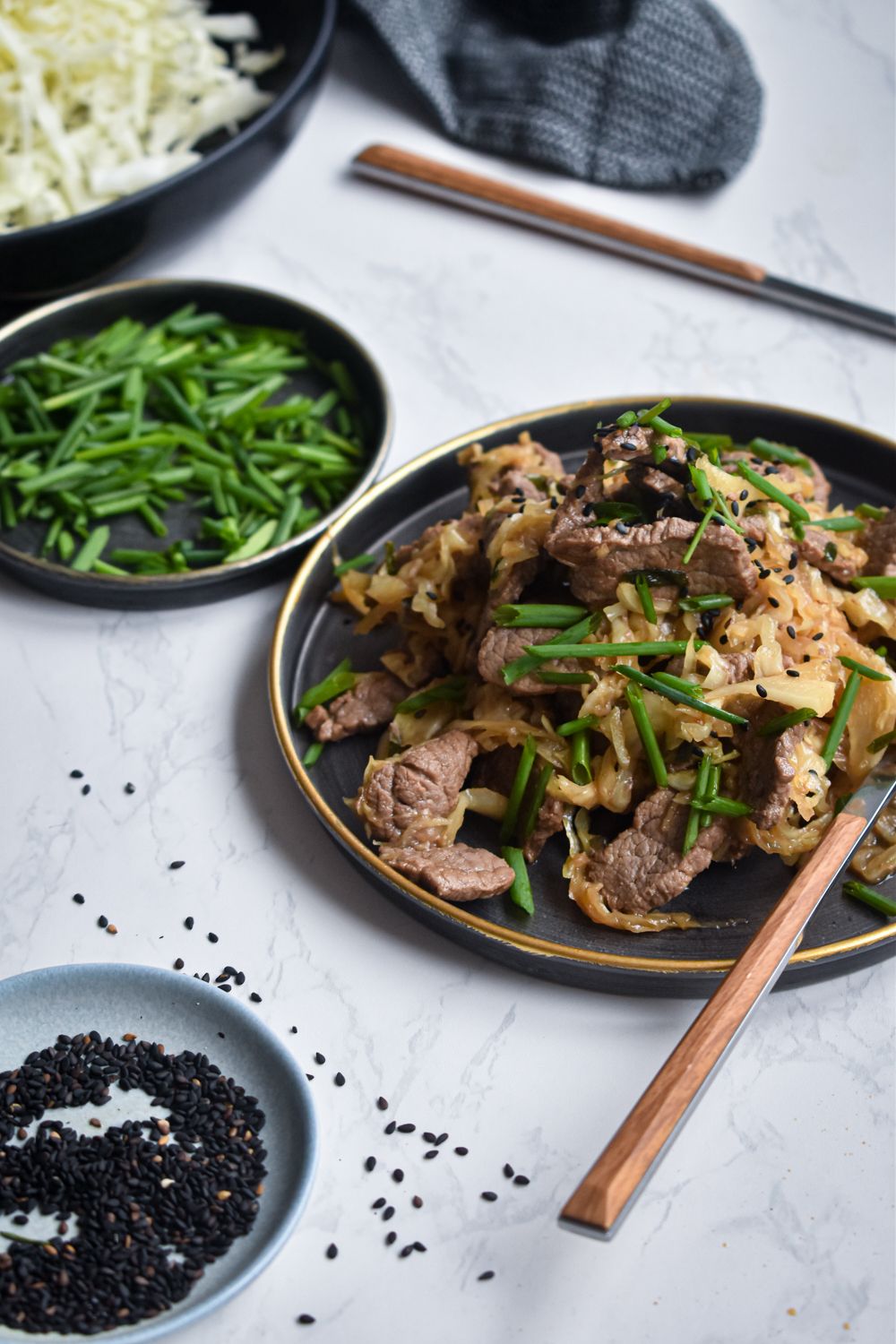 Cabbage and beef stir fry on a plate with shredded cabbage, thinly sliced beef, and a ginger and garlic stir fry sauce.