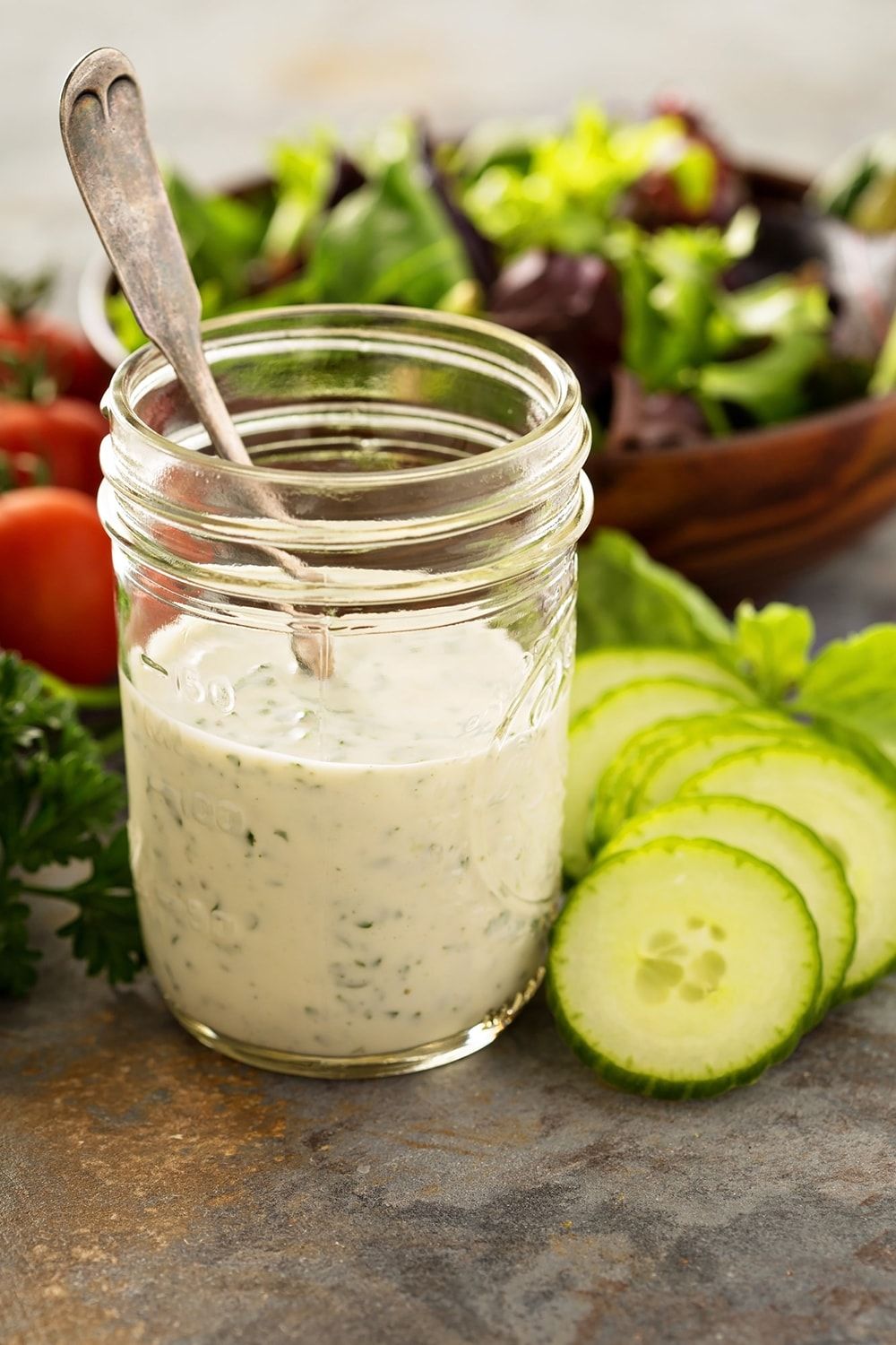 Ranch Dressing in a mason jar with lettuce in the background.