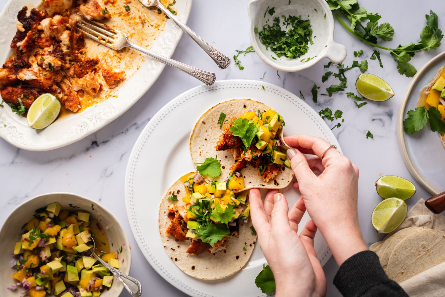 Blackened fish served with mango avocado salsa in corn tortillas for tacos.