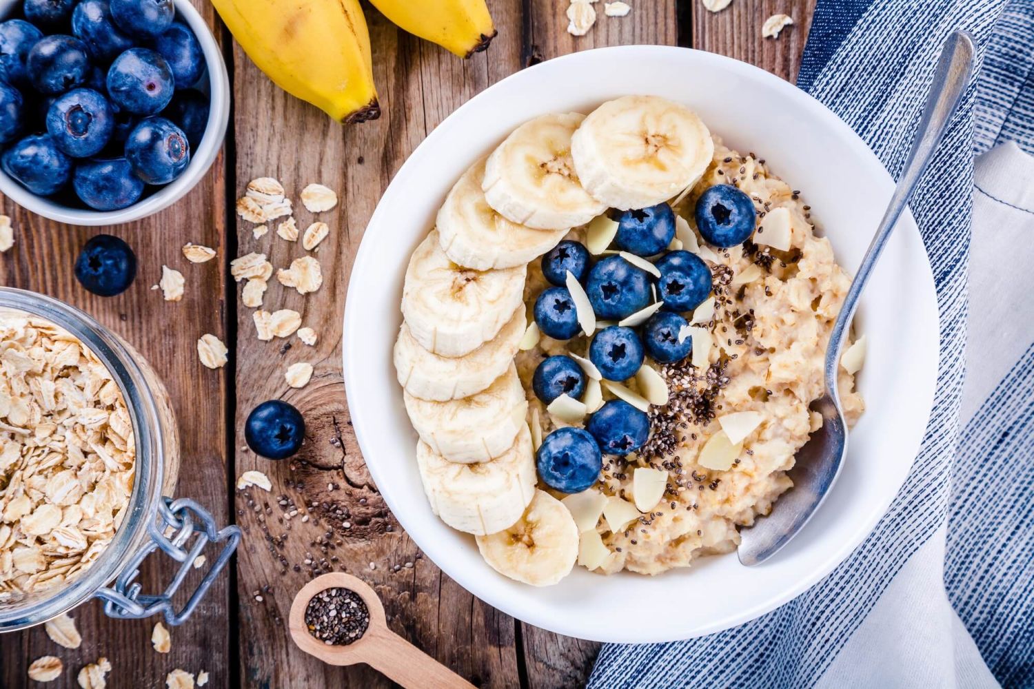 Overnights with chia seeds in a bowl with blueberries and sliced bananas around it.