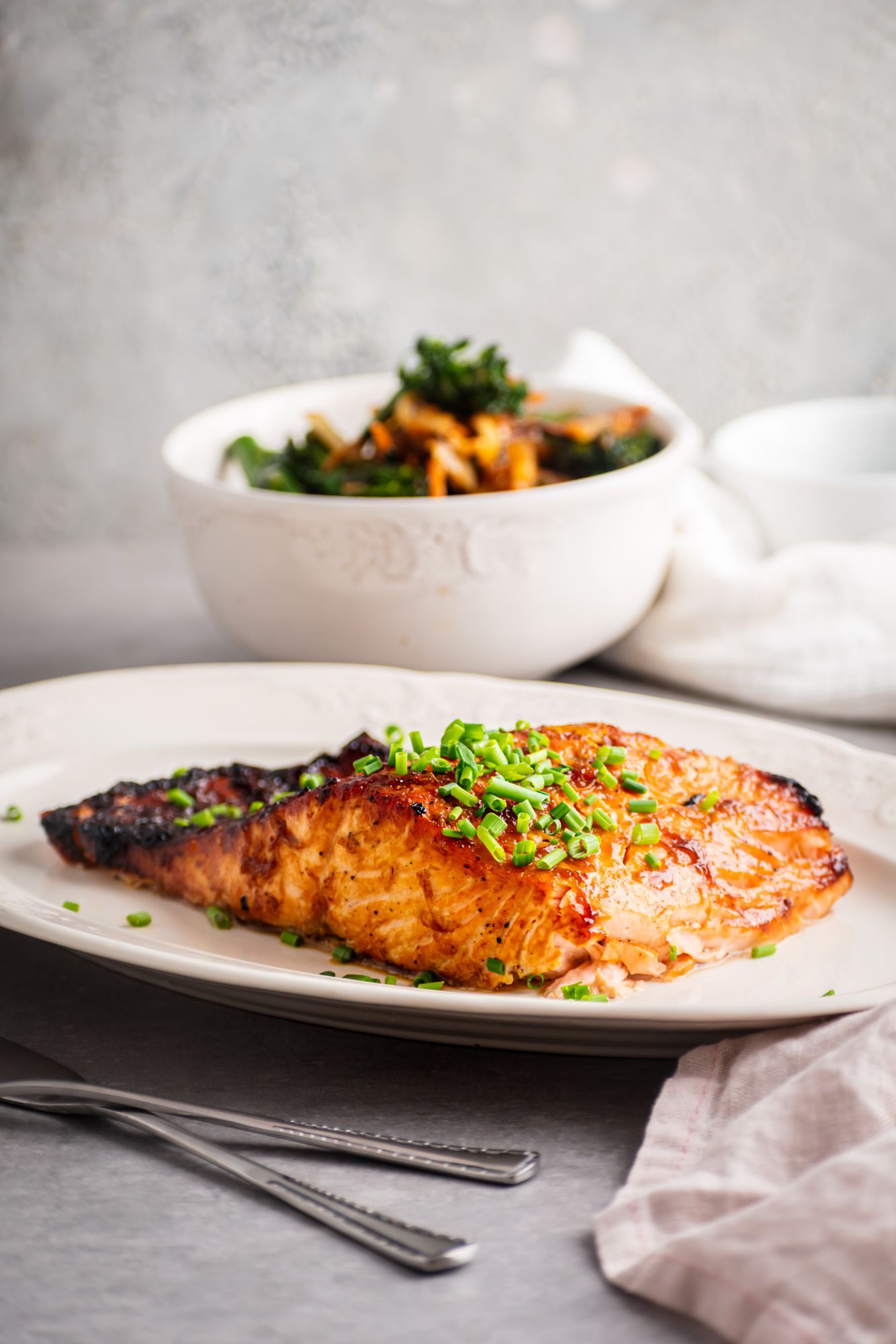 Baked brown sugar salmon with a glazed top and served with chives.