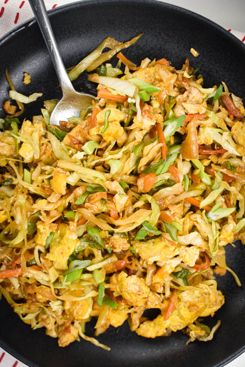 Cabbage rice that is fried with carrots, onions, garlic, ginger, and soy sauce on a plate.