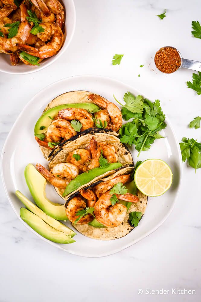 Cajun shrimp folded in tortillas with avocado and cilantro for tacos.