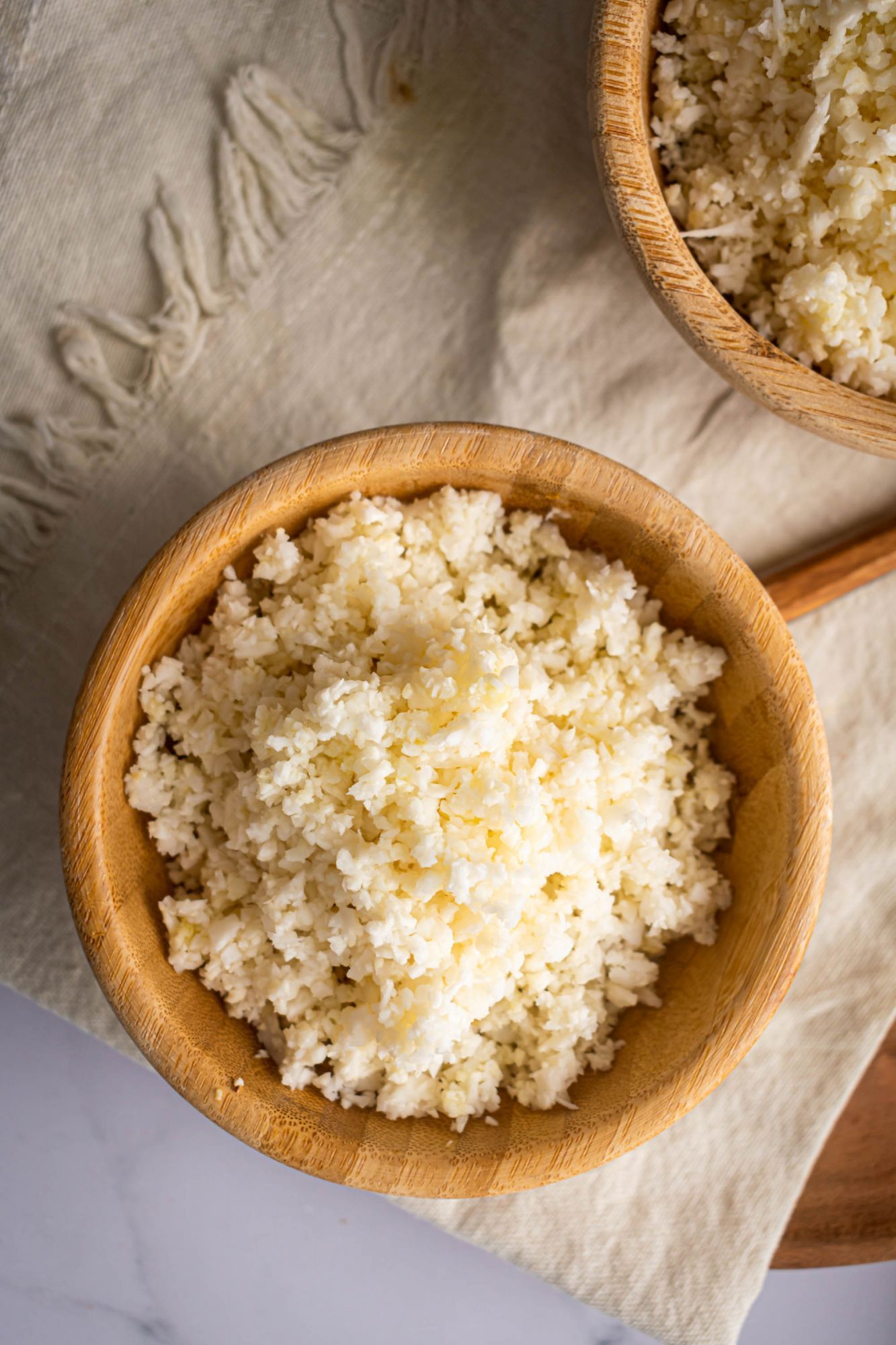 Keto cauliflower rice in a bowl with rice sized pieces of cauliflower cooked with olive oil and spices.