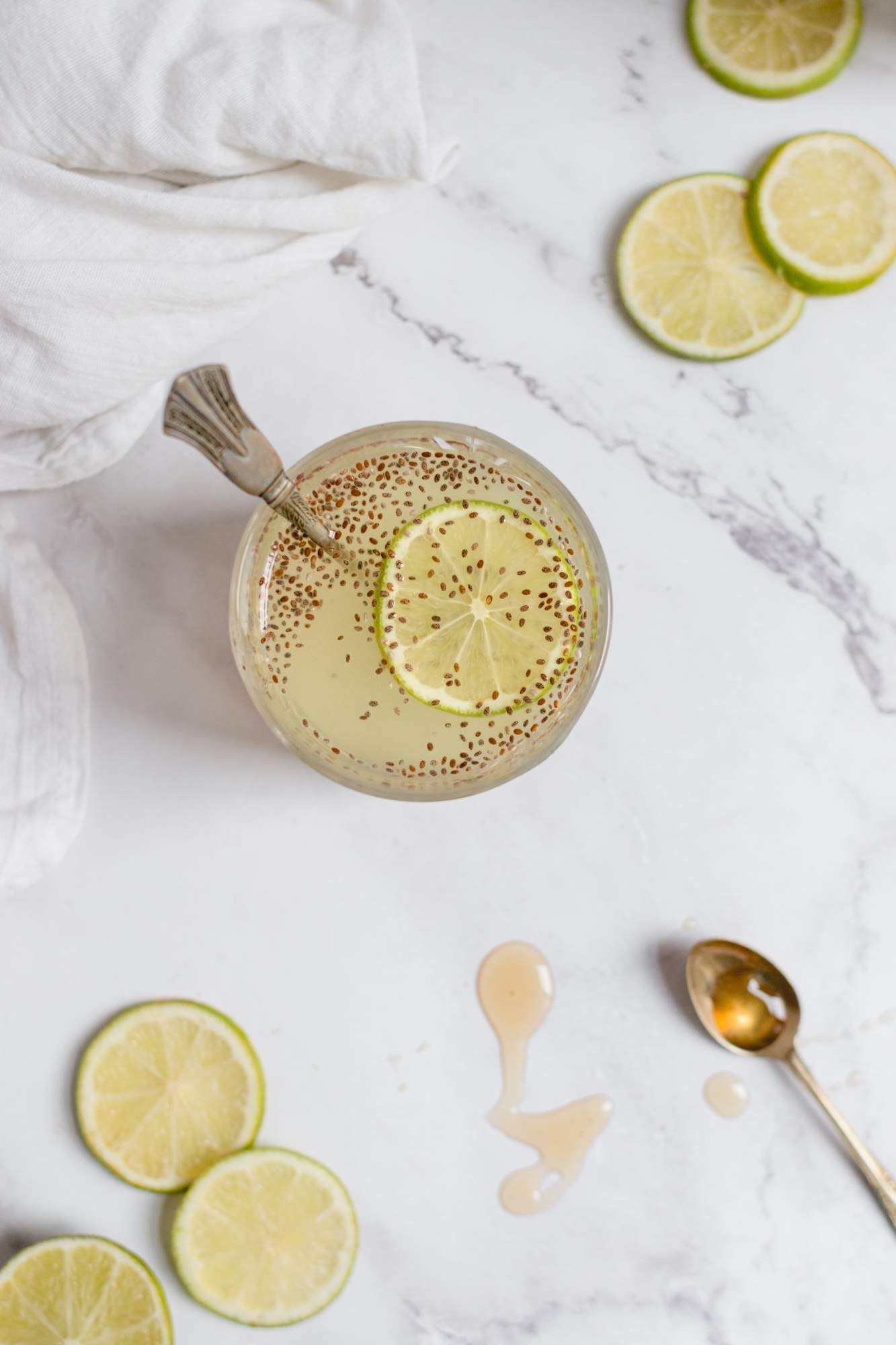 Chia drink served in a glass with chia seeds mixed with water, lime juice, and honey. 