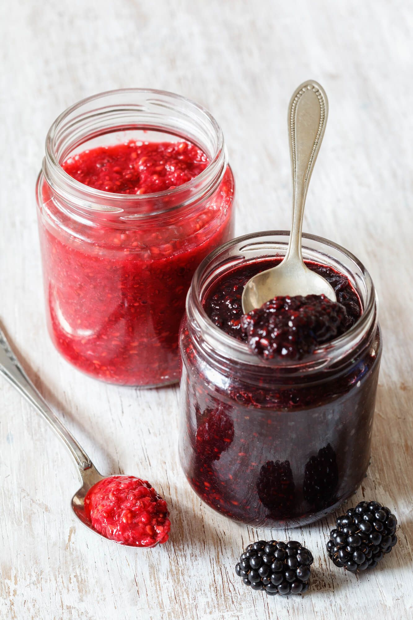 Two Chia Seed jam glass containers on a white background with spoon.