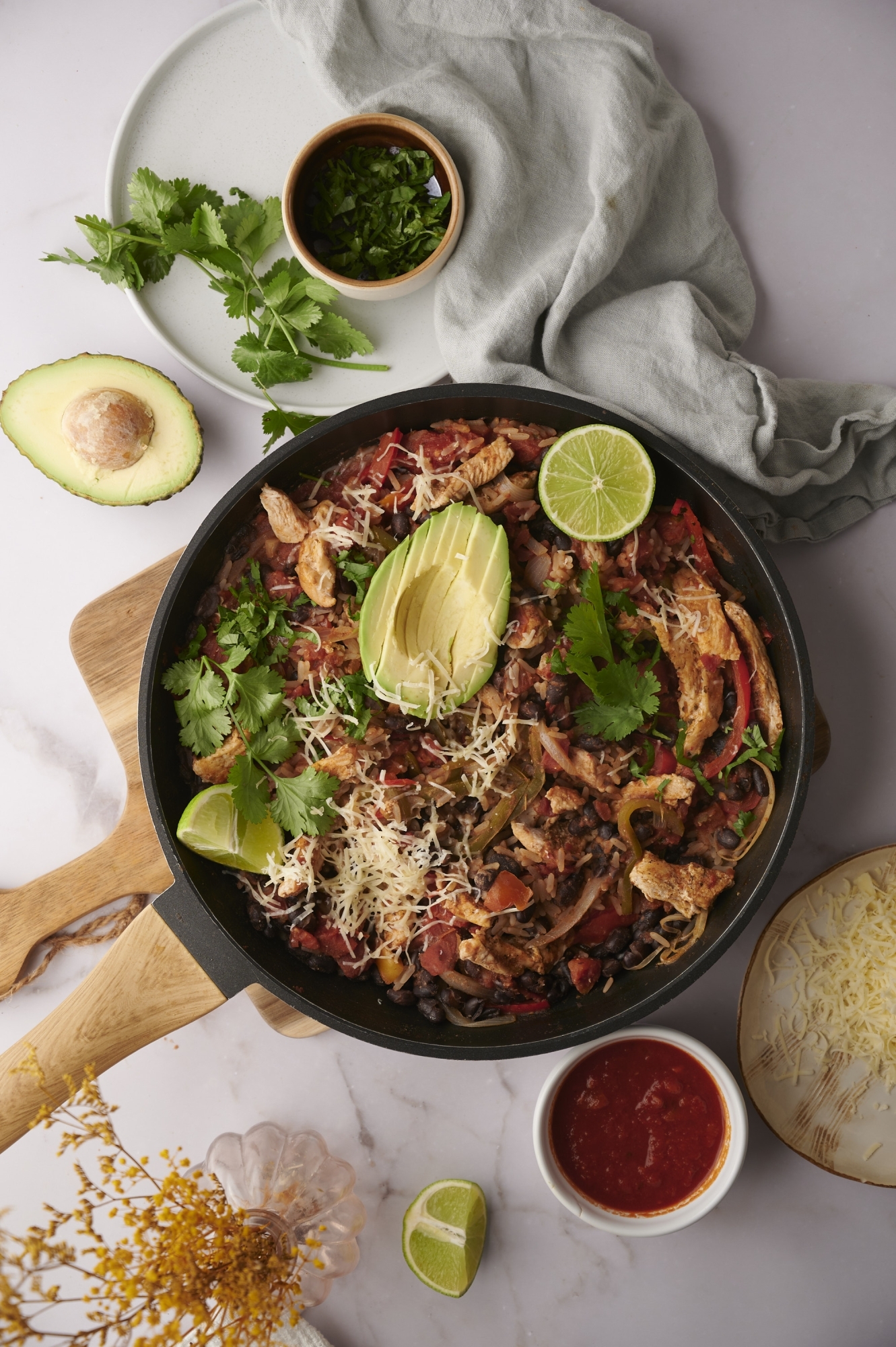 One pot chicken burrito bowls with chicken, rice, peppers, beans, avocado, and cheese.