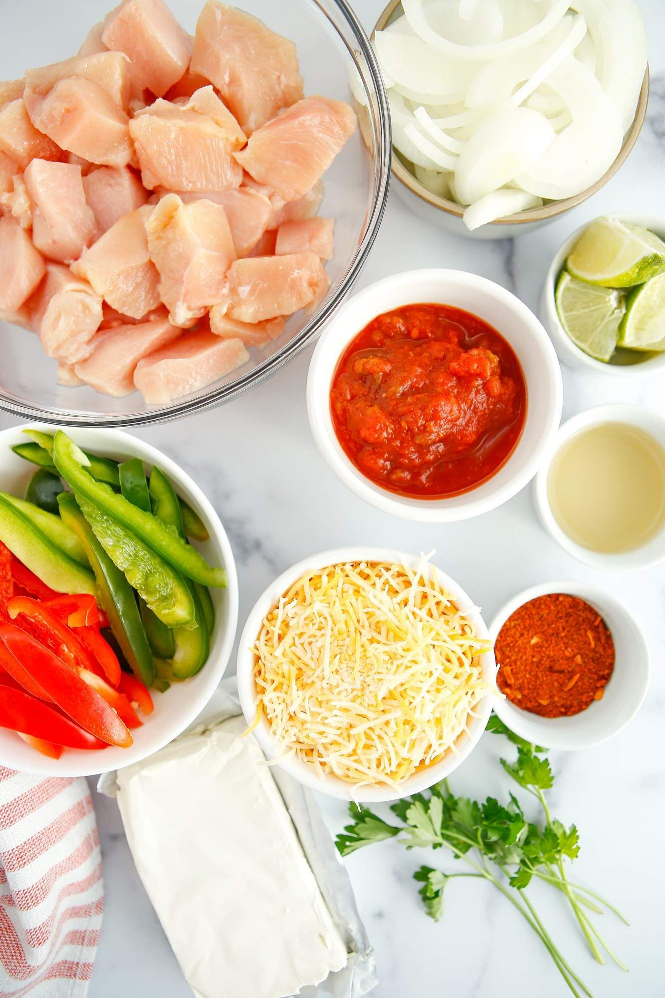 Ingredients for chicken fajita casserole including chicken breast, salsa, peppers, onions, cheese, and cream cheese.