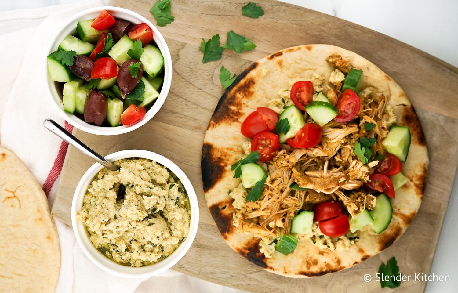 Chicken Shawarma on a wooden cutting board with hummus.