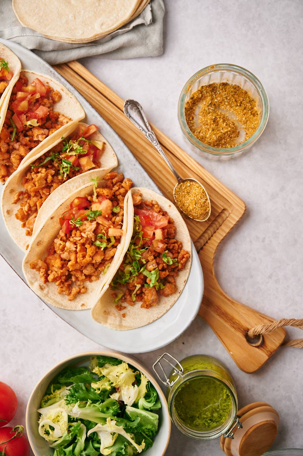 Ground chicken tacos with homemade taco seasoning served in flour tortillas with tomatoes and cilantro.