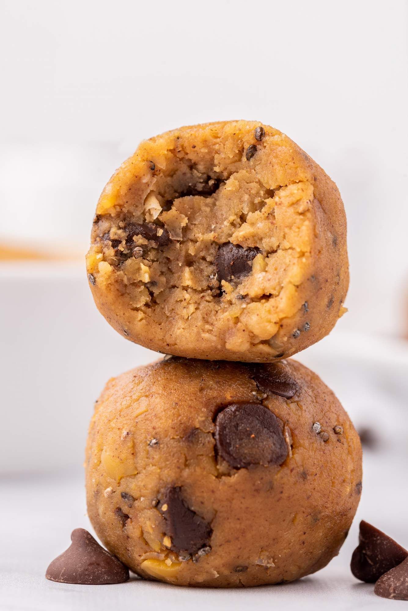 Chickpea energy bites with chocolate chips and chia seeds stacked on top of one another.