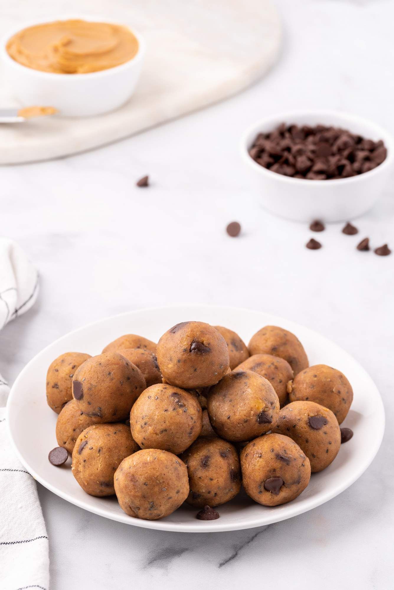 Chickpea peanut butter bites on a plate with chocolate chips and a napkin.