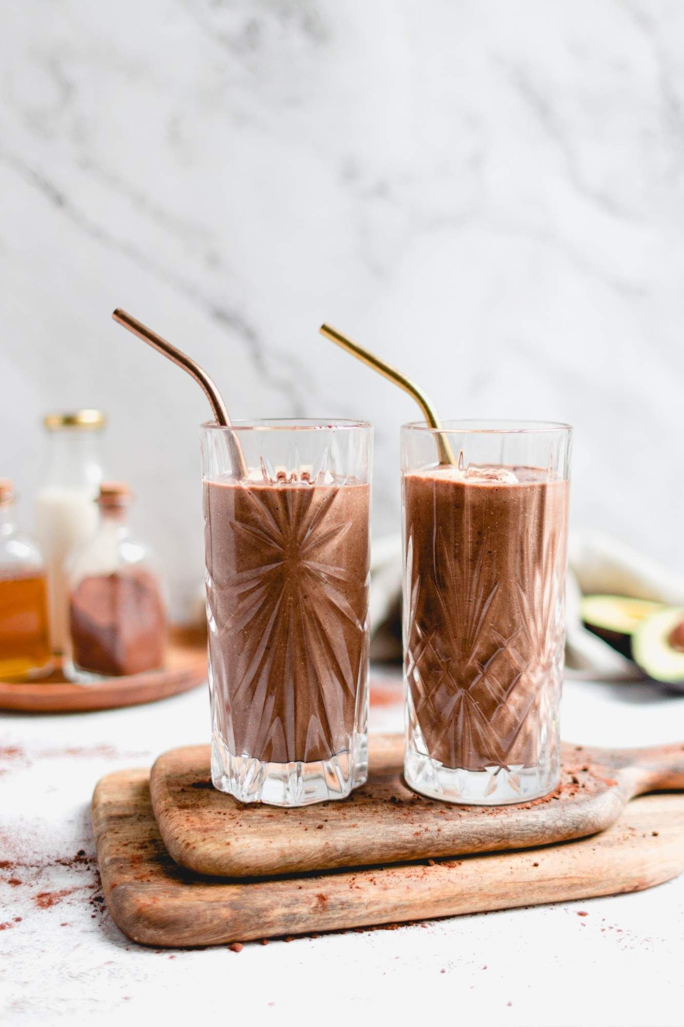 Chocolate and avocado smoothie in two glasses with bananas, avocado, almond milk. and chia seeds.