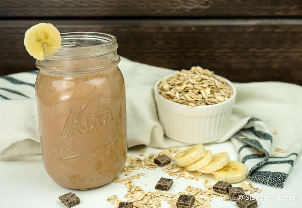 Chocolate smoothie with banana in a glass on a wooden table.