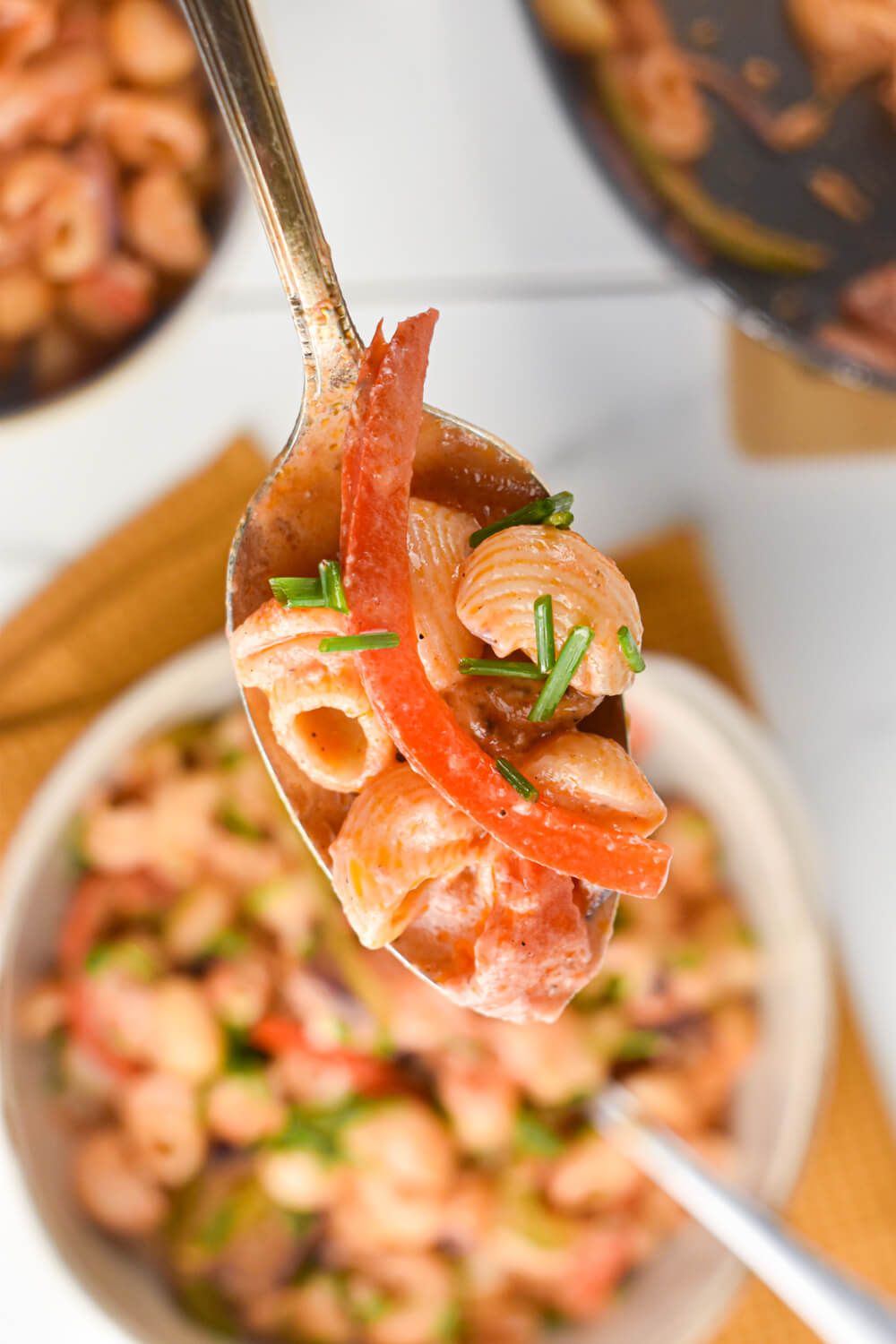 Cajun Pasta with chicken breast, creamy Cajun sauce, and vegetables on a spoon.