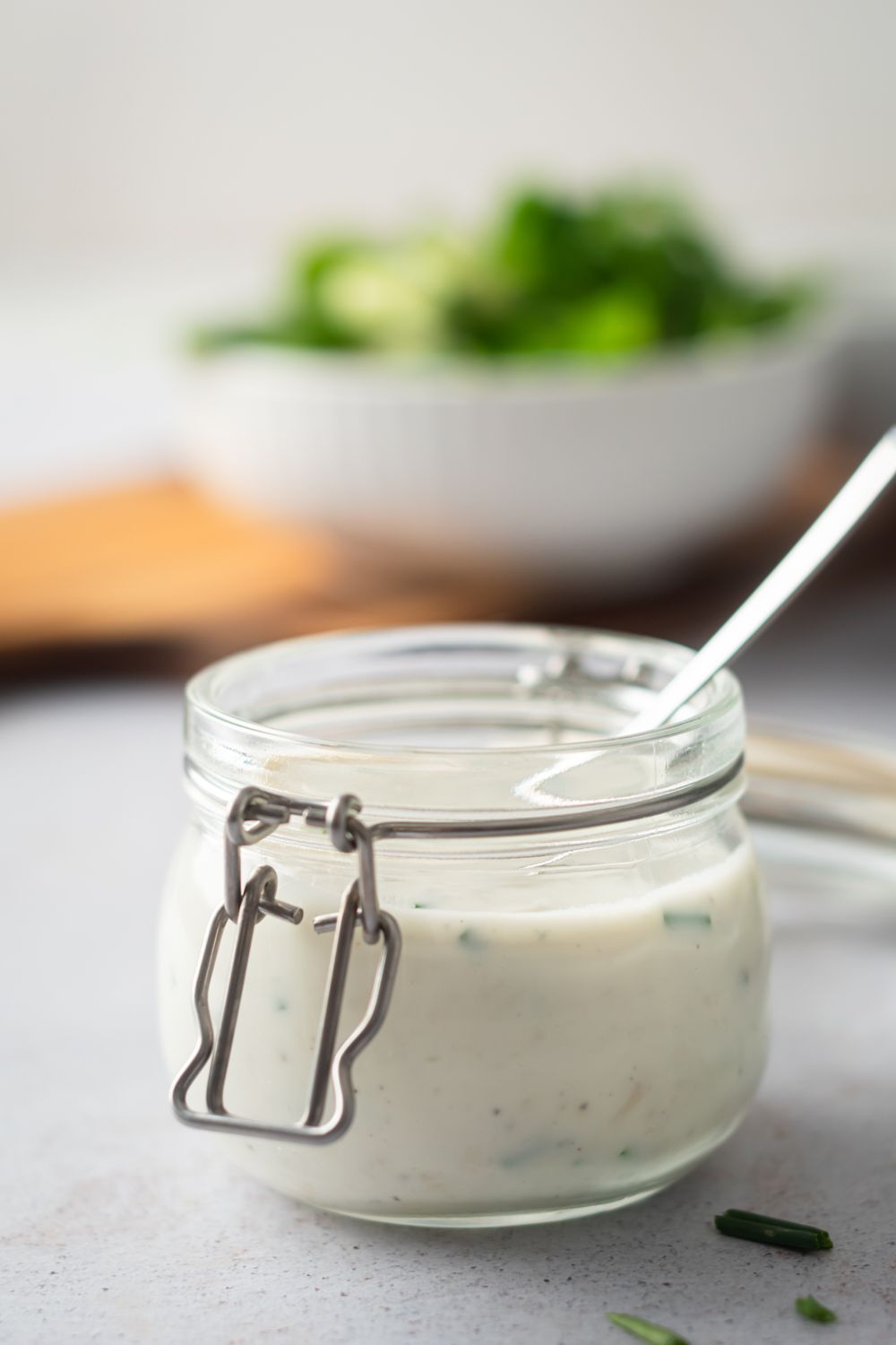 Gorgonzola salad dressing made with Greek yogurt, gorgonzola cheese, and chives in a glass jar.