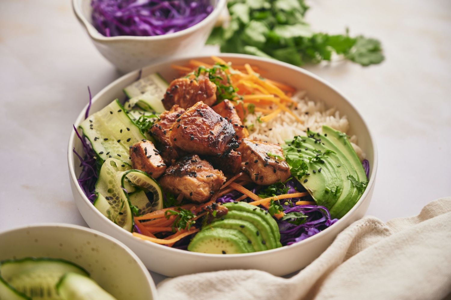 Salmon bowl with rice, vegetables, sesame seeds, and a ginger garlic soy sauce.