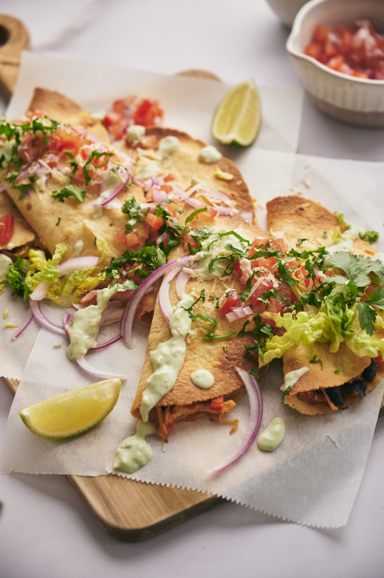 Chicken tacos in crispy corn tortillas topped with cilantro, pico de gallo, lettuce, and sour cream.