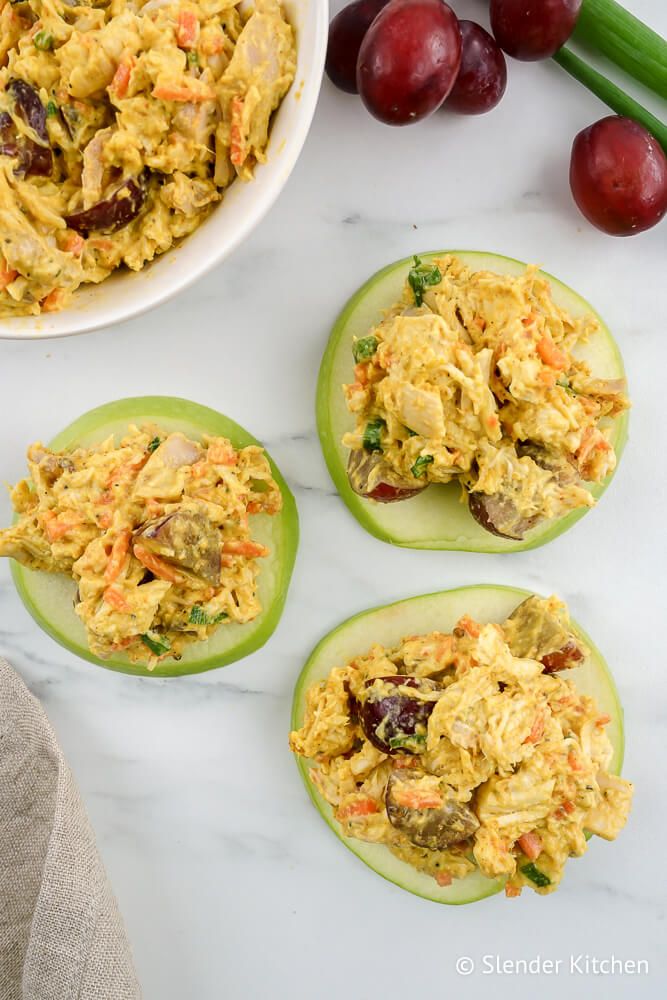 Chicken curry salad on green apple slices with grapes and carrots.