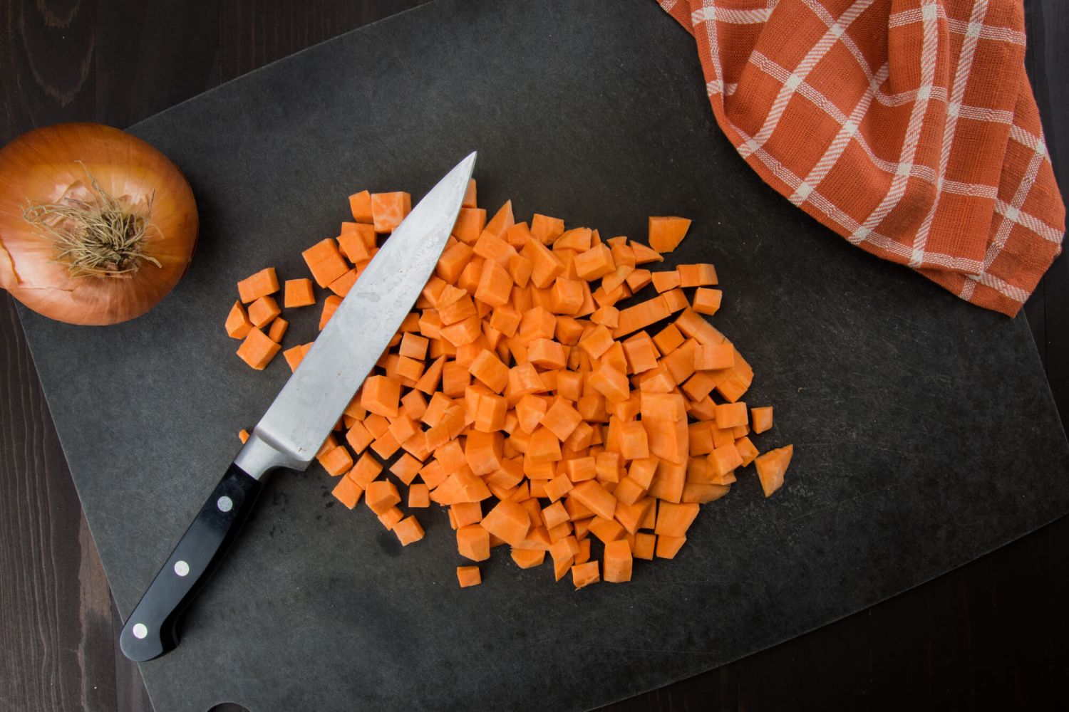 Diced sweet potatoes with an onion and a knife