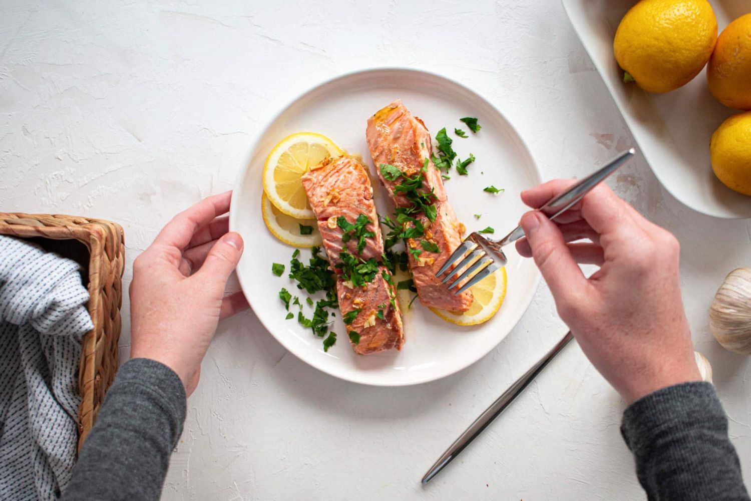 Dijon salmon with garlic and lemon on a plate with a fork taking a bite.